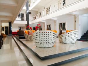 a lobby with orange and white chairs on a table at Gading Guest House in Mataram