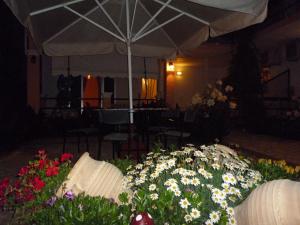 a bunch of flowers in a room with an umbrella at Kostas Apartments & studios in Agios Georgios Pagon