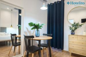 a dining room with a table and chairs and a bedroom at Hotelito Boutique Badalona Mar in Badalona