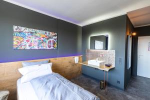 a bedroom with a bed and a sink and a mirror at Hotel Mecklenheide in Hannover