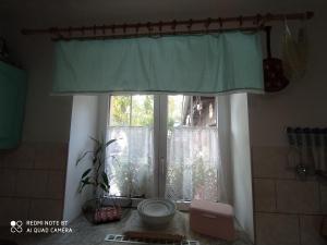 a window with a green curtain in a bathroom at Apartmány Friday in Liberec