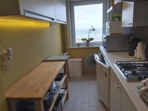 a kitchen with a counter top and a window at Appartement met zeezicht in Blankenberge