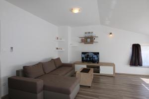 uma sala de estar com um sofá e uma televisão em Apartment Petra em Šilo