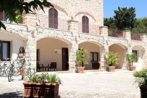Una donna in piedi di fronte a un palazzo di Hotel Castel Miramonti a Selva di Fasano
