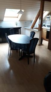 HilchenbachにあるFerienwohnung Bäumenerのキッチン付きの客室で、テーブルと椅子が備わります。
