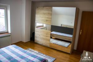 a bedroom with a large mirror and a bed at Apartman Jela in Kupres