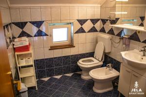 a bathroom with a toilet and a sink and a window at Apartman Jela in Kupres