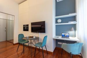 a living room with a table and chairs and a laptop at BePlace Garibaldi Suites in Milan
