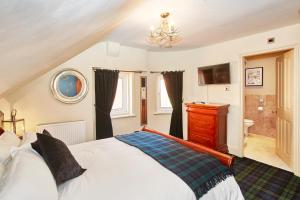 1 dormitorio con 1 cama grande y baño en Dillons of Whitby en Whitby