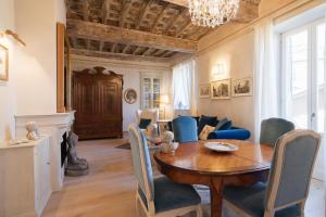 uma sala de estar com uma mesa de madeira e cadeiras azuis em La Casa di Lucia em Cortona