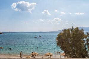 a beach with people in the water and umbrellas at Santana Beach in Agia Anna Naxos