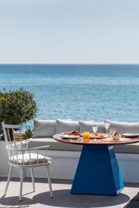 
a table with a white tablecloth and chairs on a beach at Santana Beach in Agia Anna Naxos

