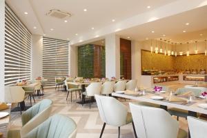 a restaurant with tables and chairs and a bar at Click Hotel Bangalore - International Airport in Devanahalli-Bangalore