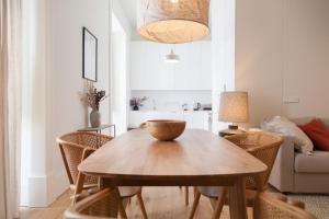uma sala de jantar com uma mesa de madeira e cadeiras em FLH Praça Comércio Bright Flat em Lisboa