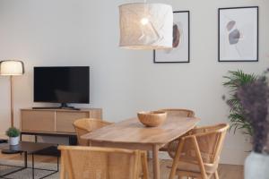 ein Wohnzimmer mit einem Holztisch und Stühlen in der Unterkunft FLH Praça Comércio Bright Flat in Lissabon