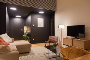 ein Wohnzimmer mit einem Sofa und einem Flachbild-TV in der Unterkunft FLH Praça Comércio Bright Flat in Lissabon
