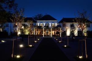 un edificio con luces delante de él por la noche en Boutique hotel & brasserie de Heerlyckheid en Bredevoort