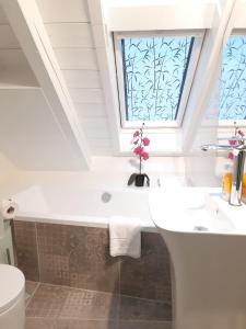 ein Bad mit einem Waschbecken und einem Fenster in der Unterkunft Haus Seeblick in Herrsching am Ammersee