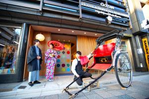 a man sitting on a bike in front of a store at Gozan Hotel & Serviced Apartment Higashiyama Sanjo in Kyoto
