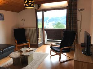 ブリクセン・イム・ターレにあるAppartement Brixen im Thaleのリビングルーム(ソファ、椅子、テレビ付)