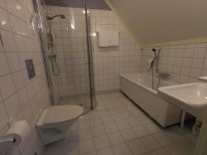 a bathroom with a toilet and a shower and a sink at Hjelle Hotel in Hjelle