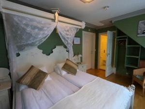 a bedroom with a large white bed with a canopy at Hjelle Hotel in Hjelle