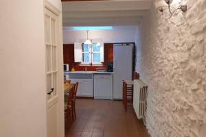a kitchen with a white refrigerator and a table and chairs at Ca la Caterina in Peratallada +19 photos