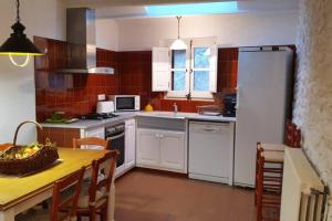 a kitchen with a table and a white refrigerator at Ca la Caterina in Peratallada