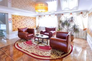 a living room with leather chairs and a table at Hotel Orenburg in Orenburg