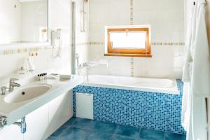 a bathroom with a tub and a sink at Alm House in Krasnaya Polyana