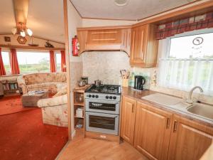 a kitchen with a stove and a sink at Alken Caravan in Bushmills