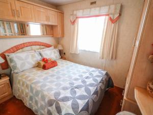 a small bedroom with a bed with a teddy bear on it at Alken Caravan in Bushmills