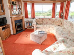 a living room with a couch and a fireplace at Alken Caravan in Bushmills