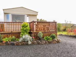 a garden with a wooden fence and some plants at Alken Caravan in Bushmills