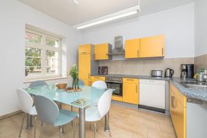 a kitchen with yellow cabinets and a table and chairs at Große Freiheit in Leipzig