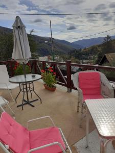 a balcony with chairs and a table and an umbrella at Casa Insorita in Sinaia