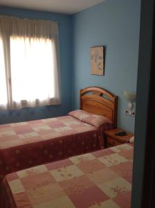 1 dormitorio con 2 camas y ventana en Hostal Los Amigos en Olivenza