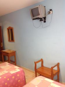 Habitación con TV en una pared azul en Hostal Los Amigos en Olivenza