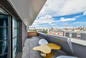 a view from the balcony of a building with a yellow stool at Hôtel B55 in Paris