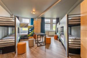 a dorm room with bunk beds and a table and chairs at a&o Hamburg Hauptbahnhof in Hamburg