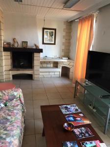 Una sala de estar con un sofá y un televisor. en Bora, en Béziers