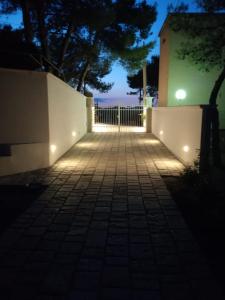 une passerelle éclairée la nuit avec une clôture dans l'établissement Villaggio Sant'Andrea, à Vieste
