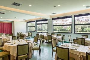 a dining room with tables and chairs and windows at Rada Siri in Montepaone