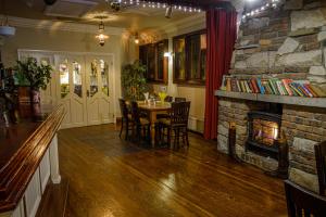 a dining room with a table and a stone fireplace at Jacob's Well Hotel in Rathdrum