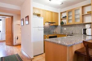 una cucina con frigorifero bianco e armadietti in legno di Vielha centro calbeto VAD apartamento a Vielha