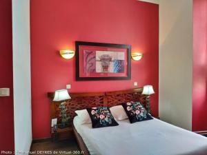 a bedroom with red walls and two beds with pillows at Queen Serenity Hotel in Redon