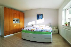 1 dormitorio con 1 cama y armario de madera en Ferienhaus/Ferienwohnung Fam. Manthey en Harrendorf