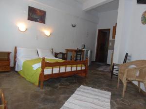 1 dormitorio con 1 cama con manta verde en Studios Milos Skopelos-Where the Sea Meets the Sky, en Skopelos Town