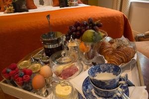a tray of food with fruit and eggs on a bed at TWO ROOMS IN BRUGES in Bruges