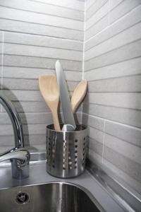 a metal container with wooden utensils in it next to a sink at Vielha centro estudio Sapporo in Vielha